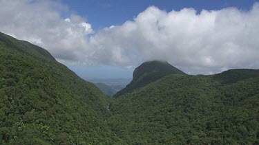 Forested mountain peaks and a shallow stream running through Daintree National Park