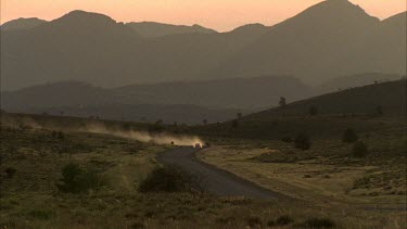 2 vehicles on dusty road