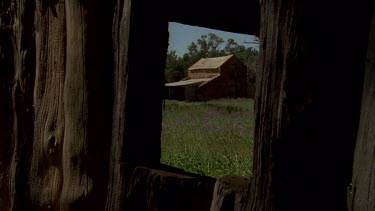 Log stable, stone barn, shot thru window