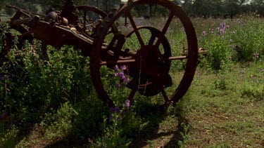 Rusty farm machinery, salvation Jane, tracking shot