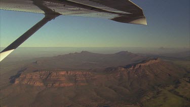 Wilpena Pound aerial. Wing of plane in foreground