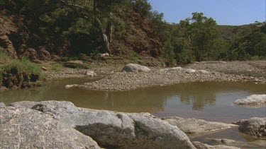 creek tilt and pan to cu of rock surface