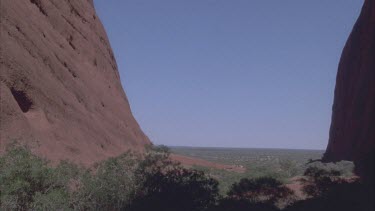 looking out from Walpa Gorge sheer rock faces of Kata Juta and onto sand plains