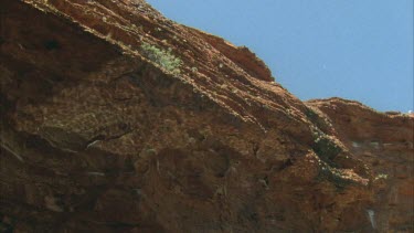 **reflections of water on the underneath of sandstone overhang over waterhole