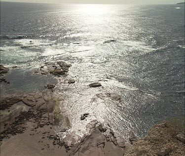 Lewis Island beach with ocean, sun shining on sea, shimmering.