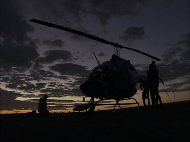 Unloading a helicopter at dusk