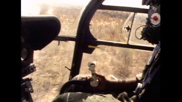 Man in helicopter looking down on rhino running, interior of helicopter