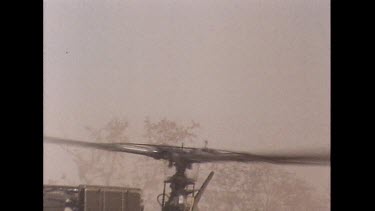 Rotor of helicopter as during take off, close up of blades. Helicopter take off through thick veil of dust