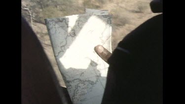In helicopter, looking at map while flying