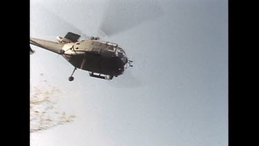 Low angle. Helicopter flying overhead.