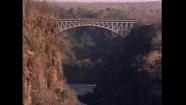 Train passes over bridge high over Zambezi river