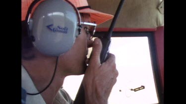 Pilot on walkie talkie while flying small propeller plane