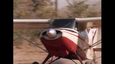 Small propeller plane take off, sand runway