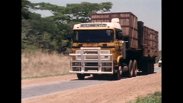 Sequence of shots. Transporting rhinos by road. The animals are transported in container crates by truck. The truck drives under a sign reading "Zimbabwe Independence 1980"