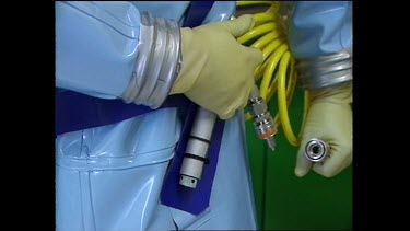 Scientist attaches oxygen tube to a connection by his hip