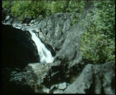 waterfall on dark and large rocks