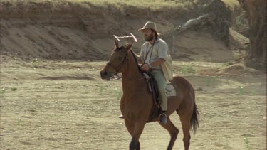 man riding horse and holding a small aerial