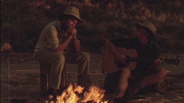 Men sitting around campfire and singing