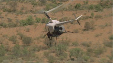 Man in helicopter aiming gun