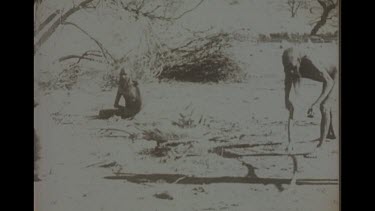 Black And White Shot Of Aboriginal Man Cooking A Dingo Carcass