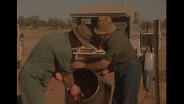 Two Men Cleaning Chunks Of Meat In Cement Mixer
