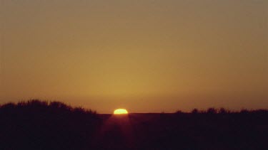 sun coming up over sand dunes and grass tussocks beautiful colours beautiful light