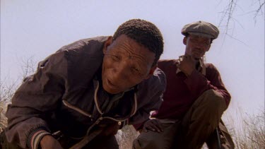 looking at bushman and Bushmen spear being poked into dark hole burrow