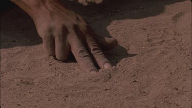 bushman fingers making prints in sand