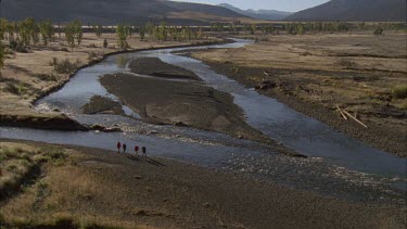 hikers walking past two rivers converging