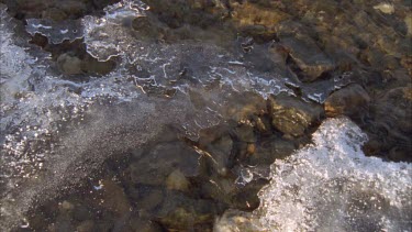 water running beneath the icy slates on top of river