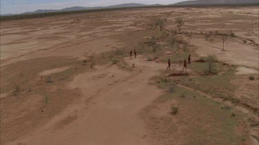 aborigines walk across red sand