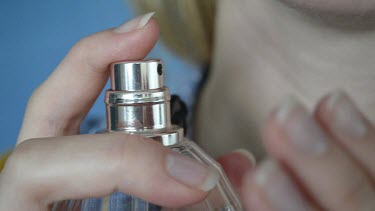 hands; lady sprays perfumes on her neck and fingers