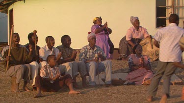 villagers local tribe woman children family clapping dancing running rejoicing festivities gathering campfire day