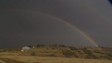 landscape scenery township village settlement dark vast rainbow colors bright dusk