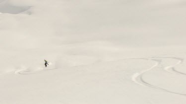 Slomo. Slo-mo. Slow motion. Snow boarding. Skiing. Snow, extreme winters sorts. Three snow boarders carve elegant curves in thick snow as they speed down a slope.
