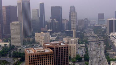 Los Angeles; LA. City skyline. Office towers, office blocks. Skyscrapers; architecture. Roads and traffic. Spaghetti junctions and highways. Lots of cars.