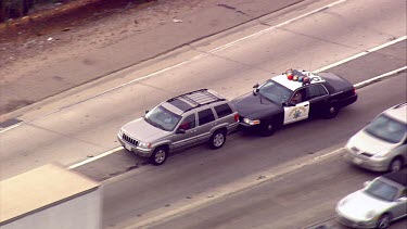 Los Angeles; LA. Highway. Roads and traffic. Highway patrolman (cop) pulls vehicle over, it pushes the car off the road.