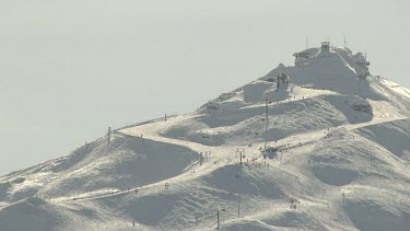 Skiers skiing down thicks snow on mountain slope. Ski slope.
