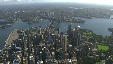 Sydney city Harbour Bridge and Opera House. Suburbs in foreground. Office blocks, towers, Centrepoint Tower. Botanic Gardens; North Sydney; North Shore;