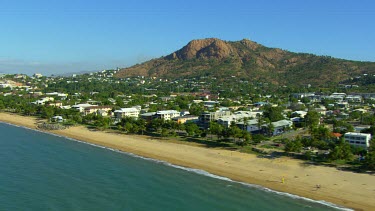 Castle Hill Townsville with "The Strand" in foreground, long strip of tropical beach with palms and hotels.