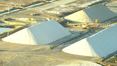 Salt mining and salt processing, manufacture Cheetham salt. Great Australian Bight. Salt produced by solar evaporation from saline or brine waters.  Small triangular mountains of salt scrapped up.