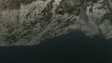 Snowy mountains reflected in clear, almost glacial, blue lakes. Slight rippling of surface.