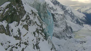 Blue glacial ice on steep mountain slope.