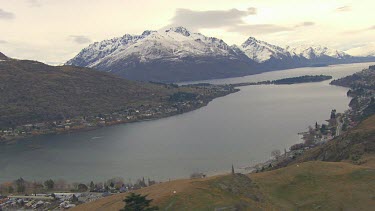 Queenstown New Zealand. Town and lake with spectaculat white snow mountains in background.