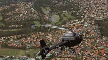 Black Helicopter flies over outlying suburbs of Sydney. See bushland and farming land too.