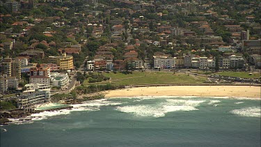 Aerial Bondi Beach, Sydney zoom out to see Sydney city, Harbour Bridge and harbour in background