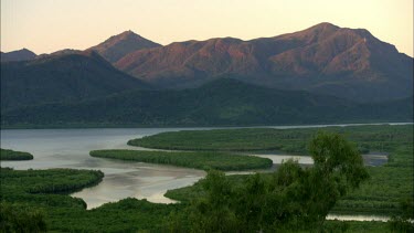 Daintree River and mountain. River meanders through tropical rainforest. Time lapse from day through sunset to dark night.