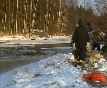 People rescue drowning moose. Moose fallen through thin ice of frozen lake. Struggling to escape out of icy waters