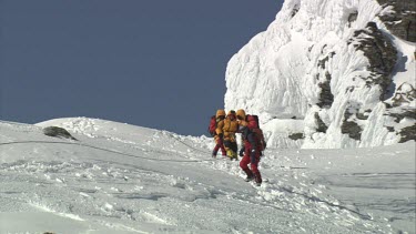 Aerial of Mount Everest: Climbers carrying troubled climber to mouintain peak