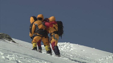 Aerial of Mount Everest: Climbers carrying troubled climber to mouintain peak